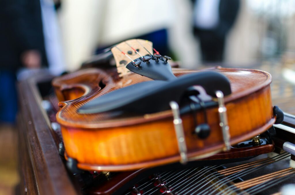 Artistic close-up of a vintage violin resting on a table, showcasing its intricate details and wooden texture.